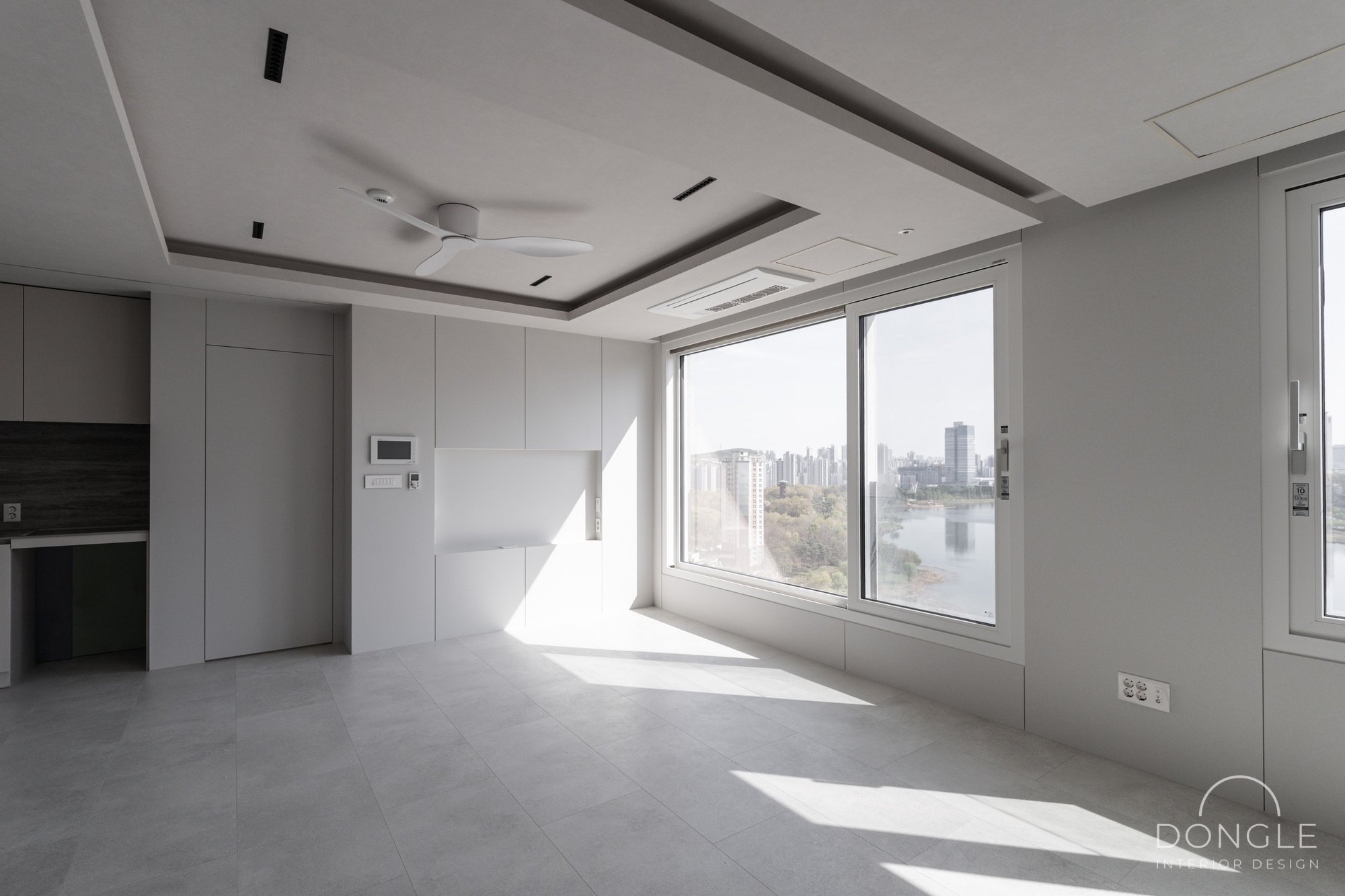 거실 — 호수 조망 창을 마주한 콘크리트 그레이 거실 전경